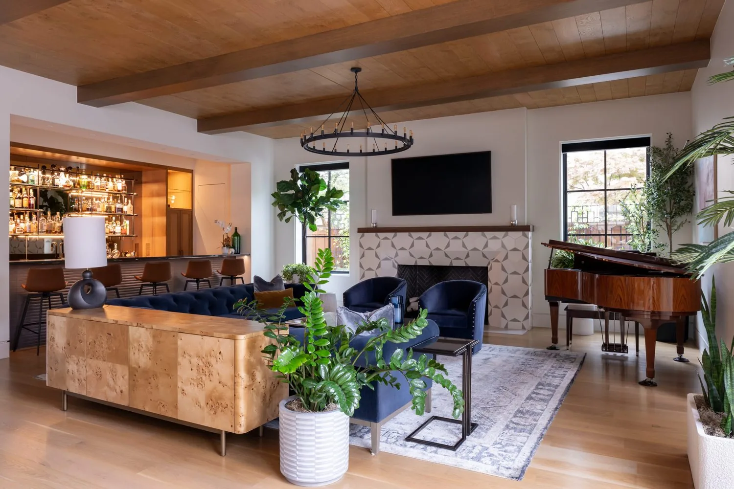 A living room with a beamed ceiling, stone fireplace and a piano