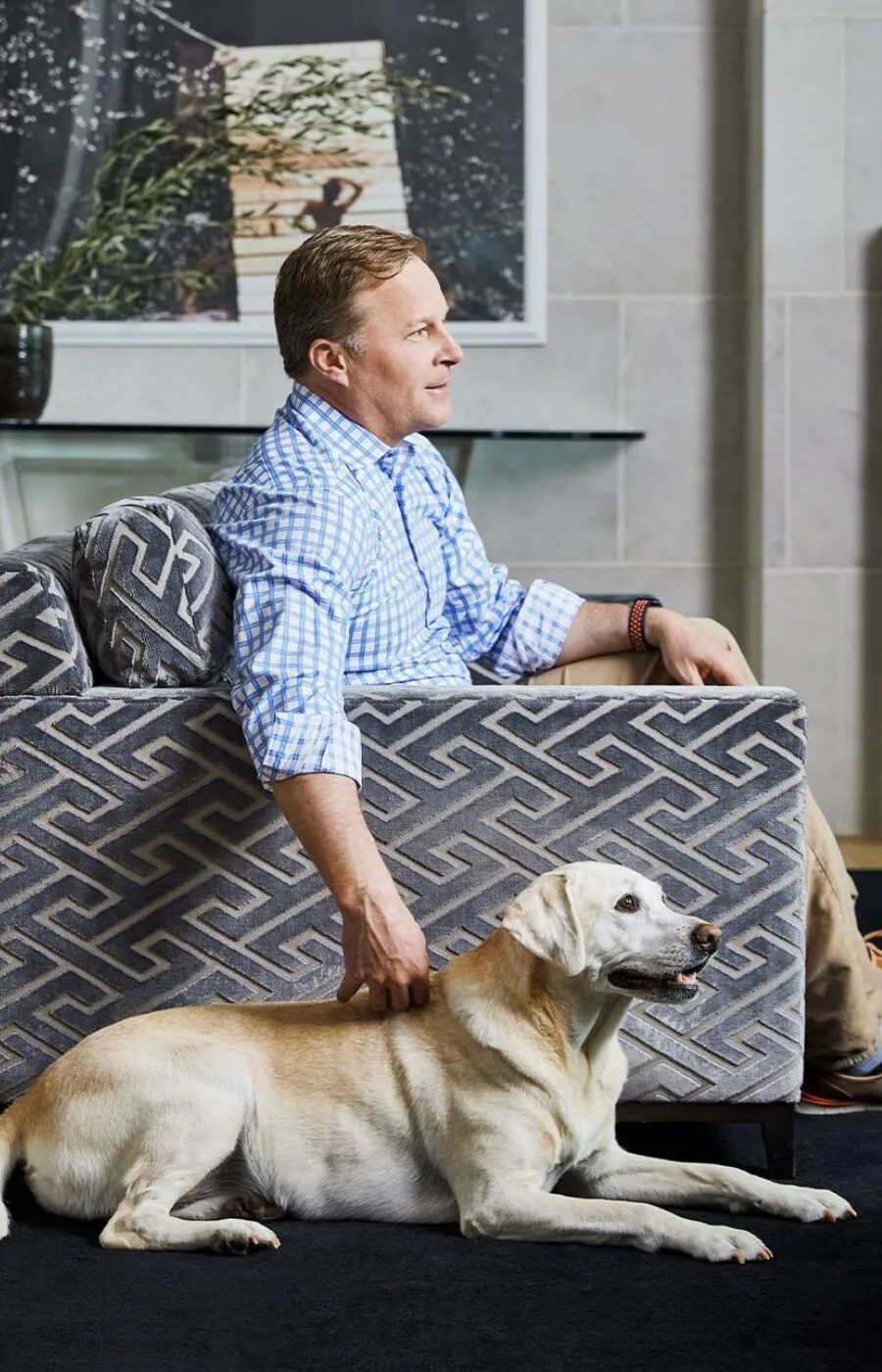 Mark Molthan seated on a sofa with his dog